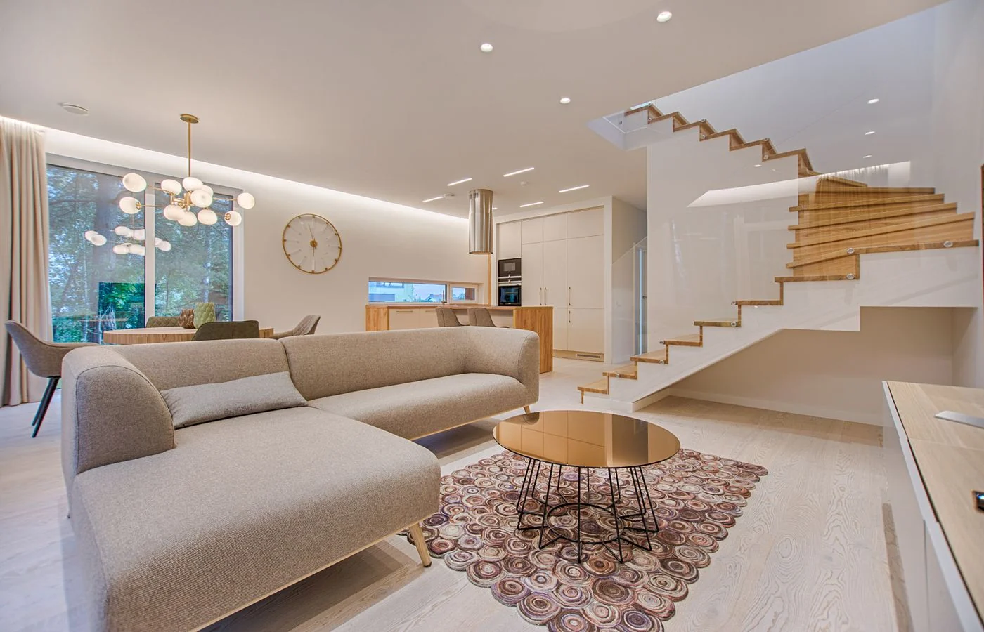 Un séjour lumineux avec un canapé et un escalier en bois